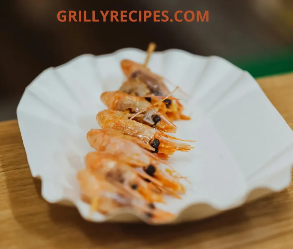 Grilled shrimp skewers served on a white plate.