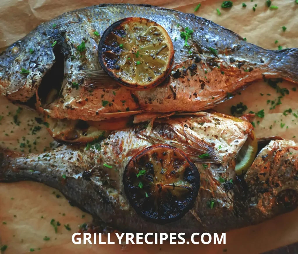 Two whole dorado fish seasoned with herbs, placed on a baking tray with chopped vegetables, including potatoes, mushrooms, cauliflower, zucchini, and red bell peppers.