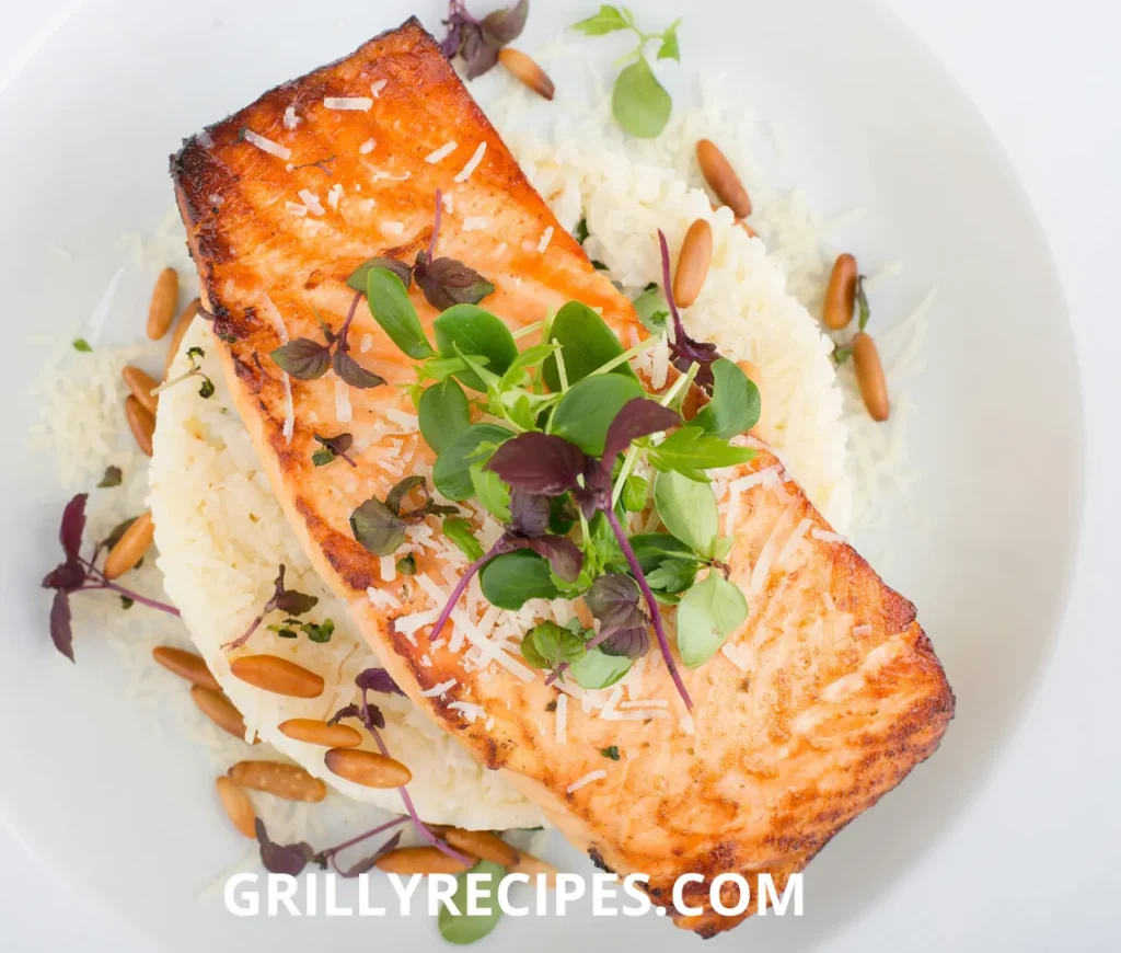 Grilled Dolphin Fish served on a bed of rice, garnished with fresh greens, parmesan cheese, and toasted pine nuts.