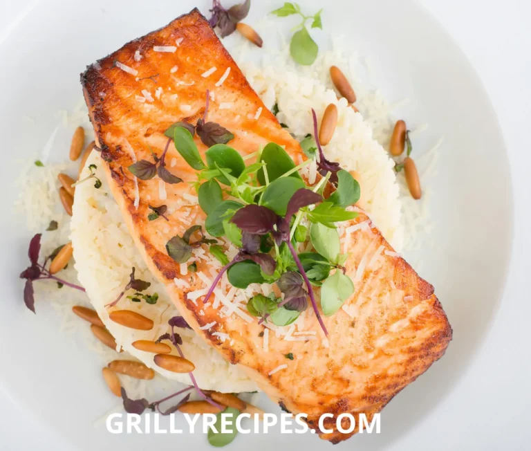 Grilled Dolphin Fish served on a bed of rice, garnished with fresh greens, parmesan cheese, and toasted pine nuts.