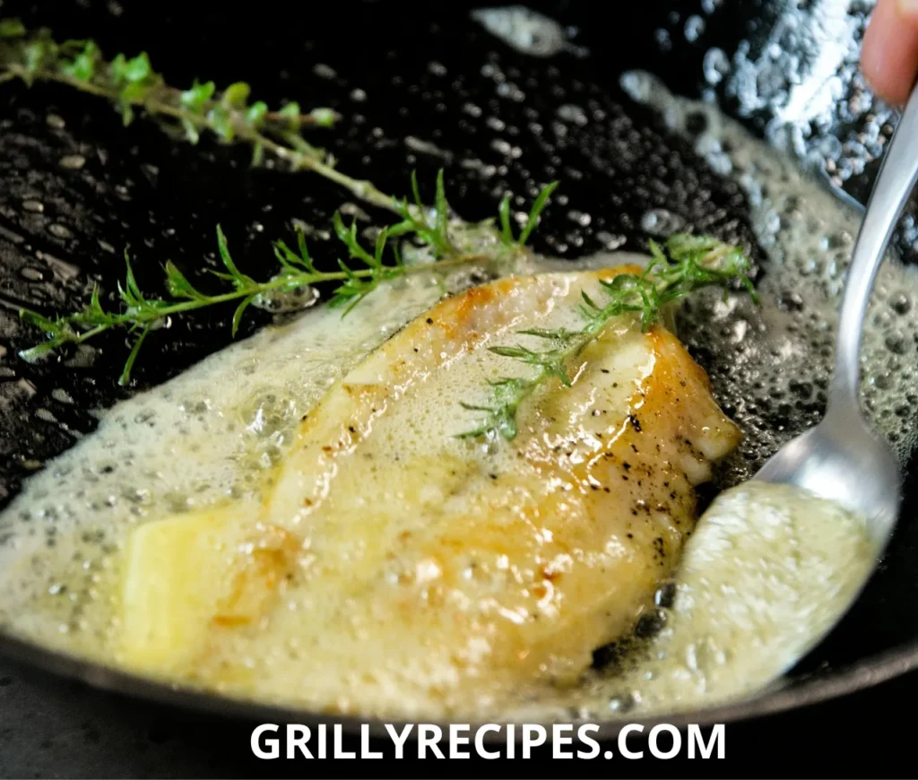 Freshly grilled branzino fillet garnished with lemon slices and herbs.


