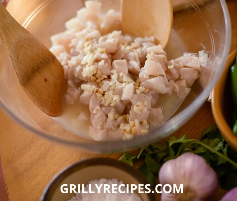 Fish and garlic dish served on a plate with fresh herbs.