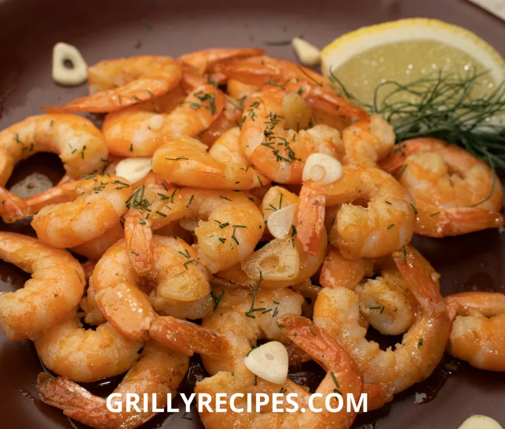 Succulent shrimp in a rich garlic butter sauce, garnished with fresh parsley and a lemon wedge on a white plate, showcasing a flavorful shrimp garlic butter recipe.