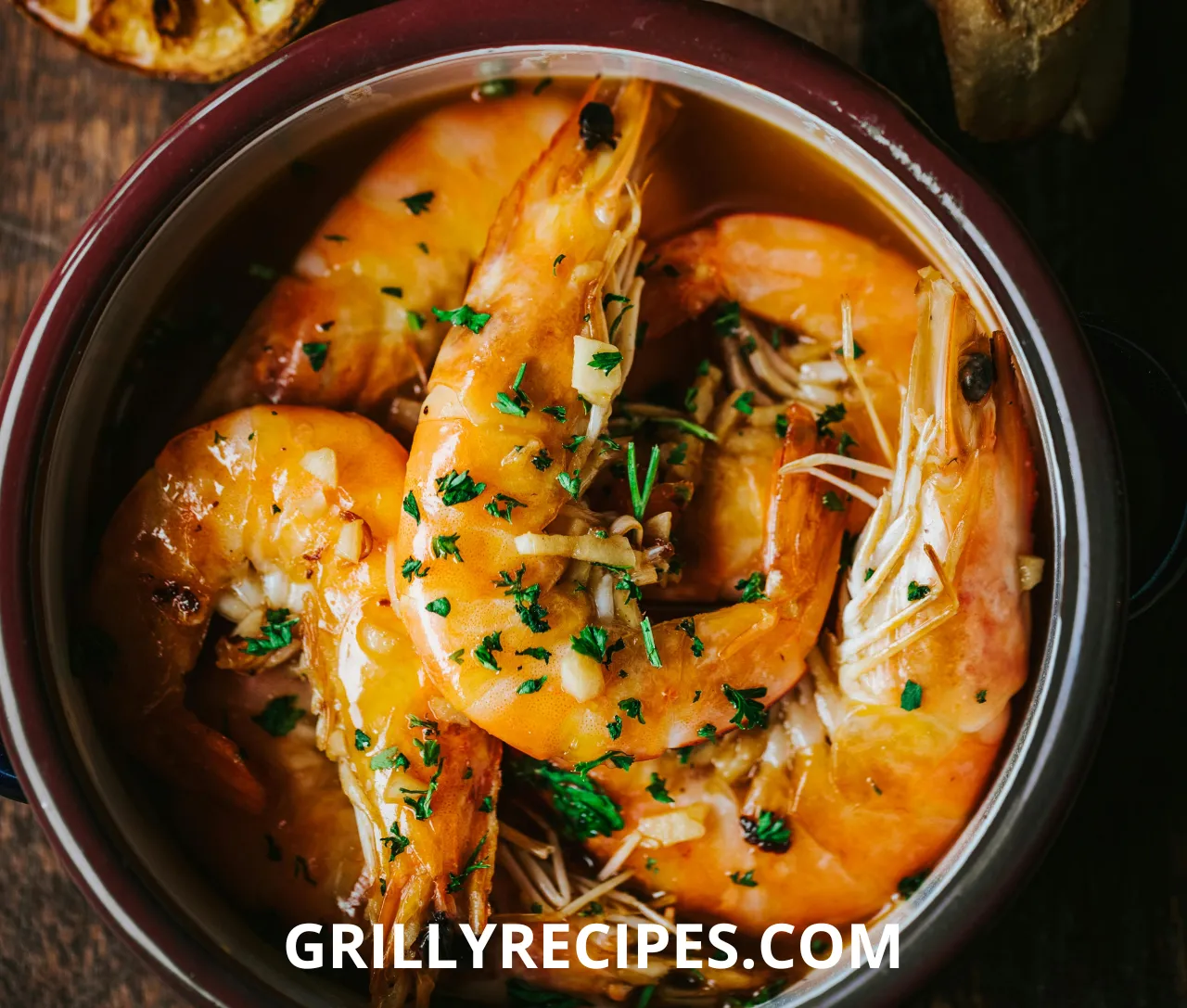 Golden stuffed shrimp with a crispy breadcrumb and Parmesan topping, garnished with fresh parsley and lemon wedges on a white platter, showcasing a delicious stuffed shrimp recipe.