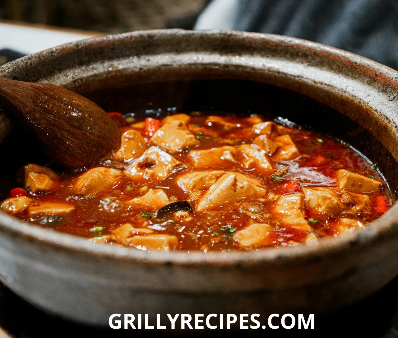 Steaming bowl of slow cooker beef chili with ground beef, kidney beans, and diced tomatoes, garnished with cilantro and sour cream, showcasing slow cooker recipes with ground beef.