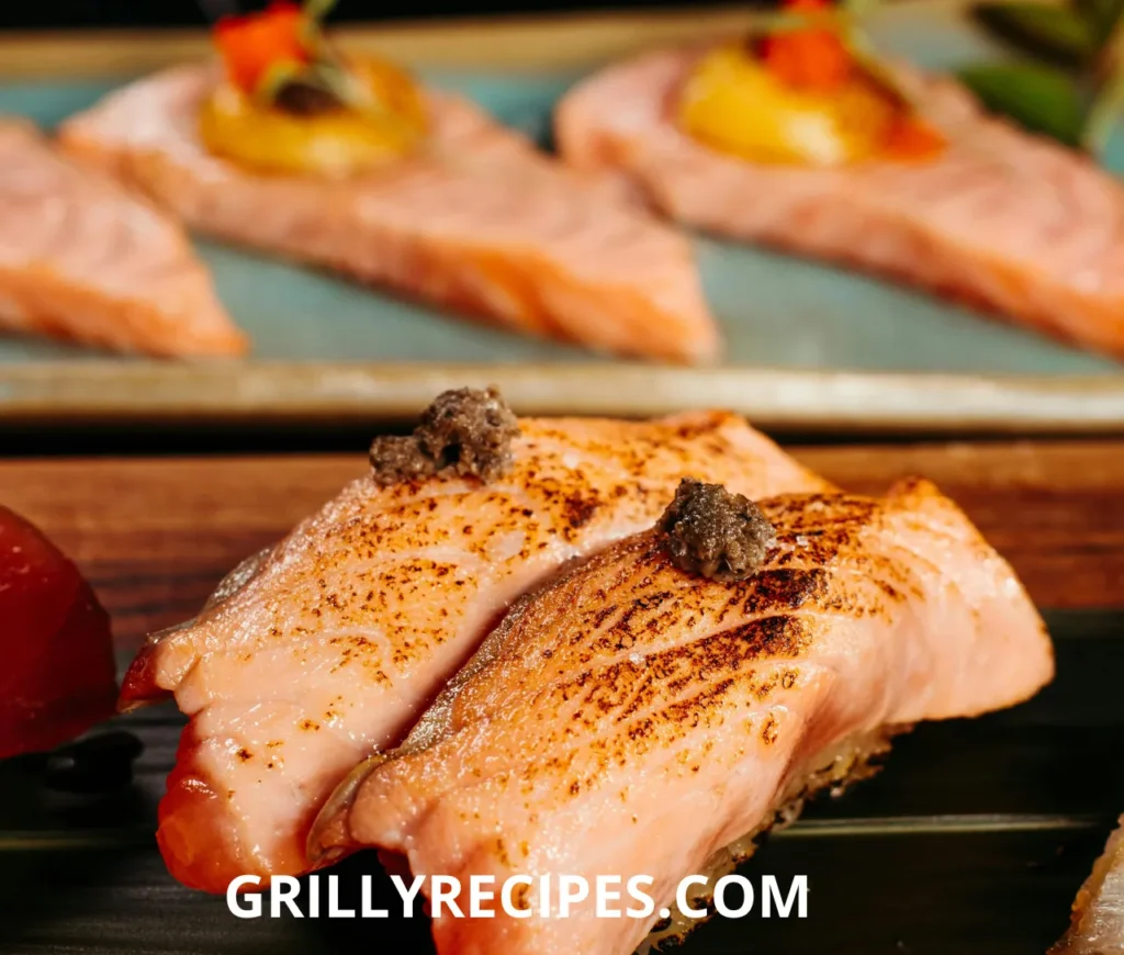 Grilled salmon fillets with a golden sear, garnished with a rich truffle topping.