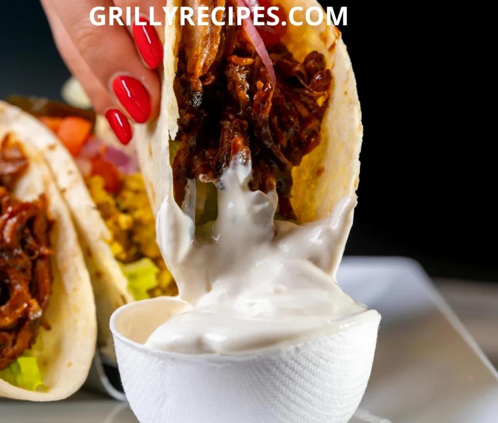 A grilled fish tacos with juicy meat dipped in creamy sauce.