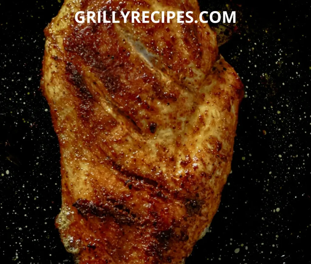 A perfectly seared Grilled Turkey Breast with a golden-brown crust on a sizzling pan.
