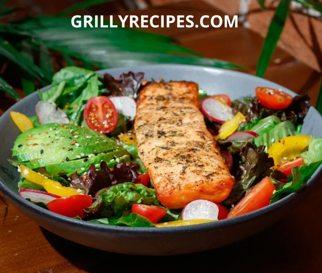 A grilled salmon fillet on a bed of fresh salad with avocado, cherry tomatoes, and radish slices.