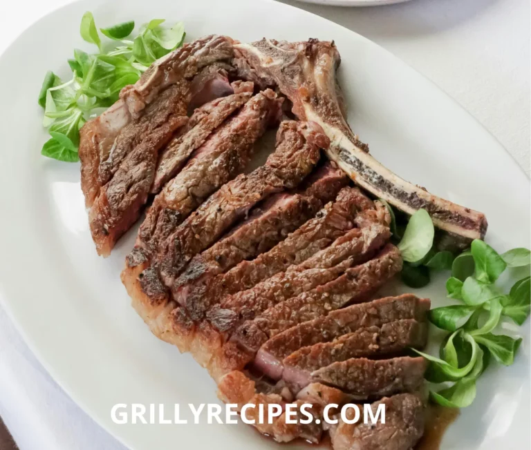 Grilled beef ribs sliced on a plate with fresh greens