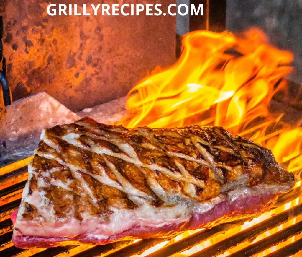 Juicy beef steak with a crispy seared crust grilling over an open flame.