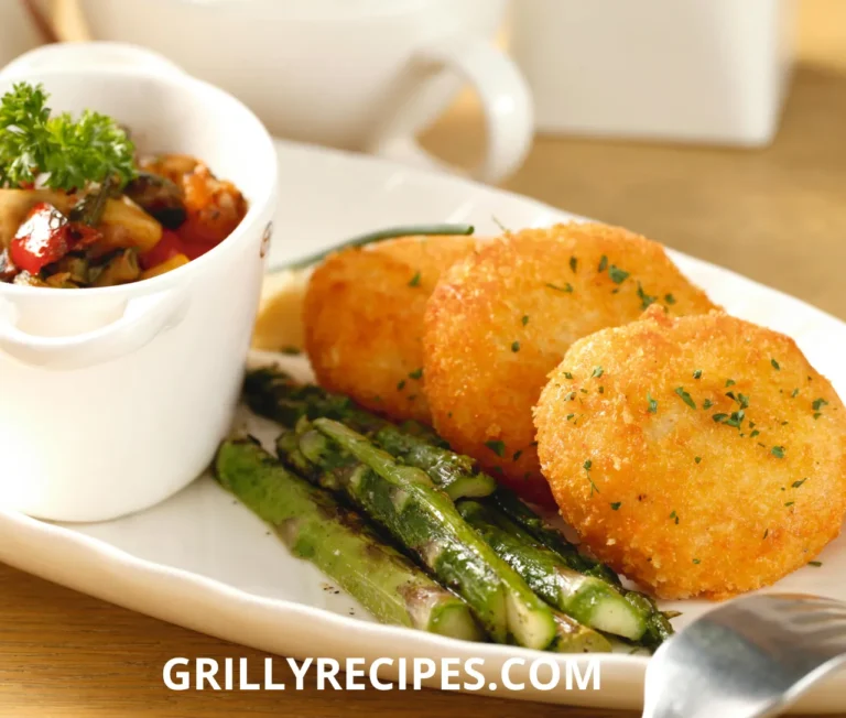 Grilled scallops with a golden sear, served with lemon wedges and fresh herbs on a white plate.