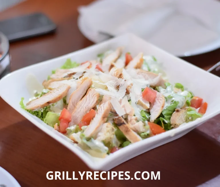 Creamy canned chicken salad with chunks of chicken, celery, cranberries, and almonds in a rustic white bowl, garnished with fresh parsley, showcasing a delicious canned chicken salad recipe.